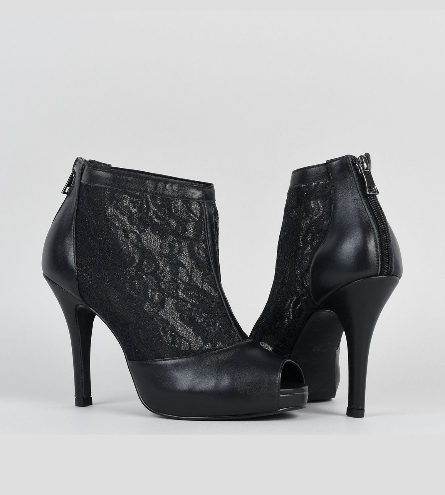 Ankle Boot sofisticada em couro com detalhes em renda preta, salto fino de 10 cm e meia pata embutida, perfeita para compor looks elegantes e versáteis com vestidos, saias midi ou calças skinny.