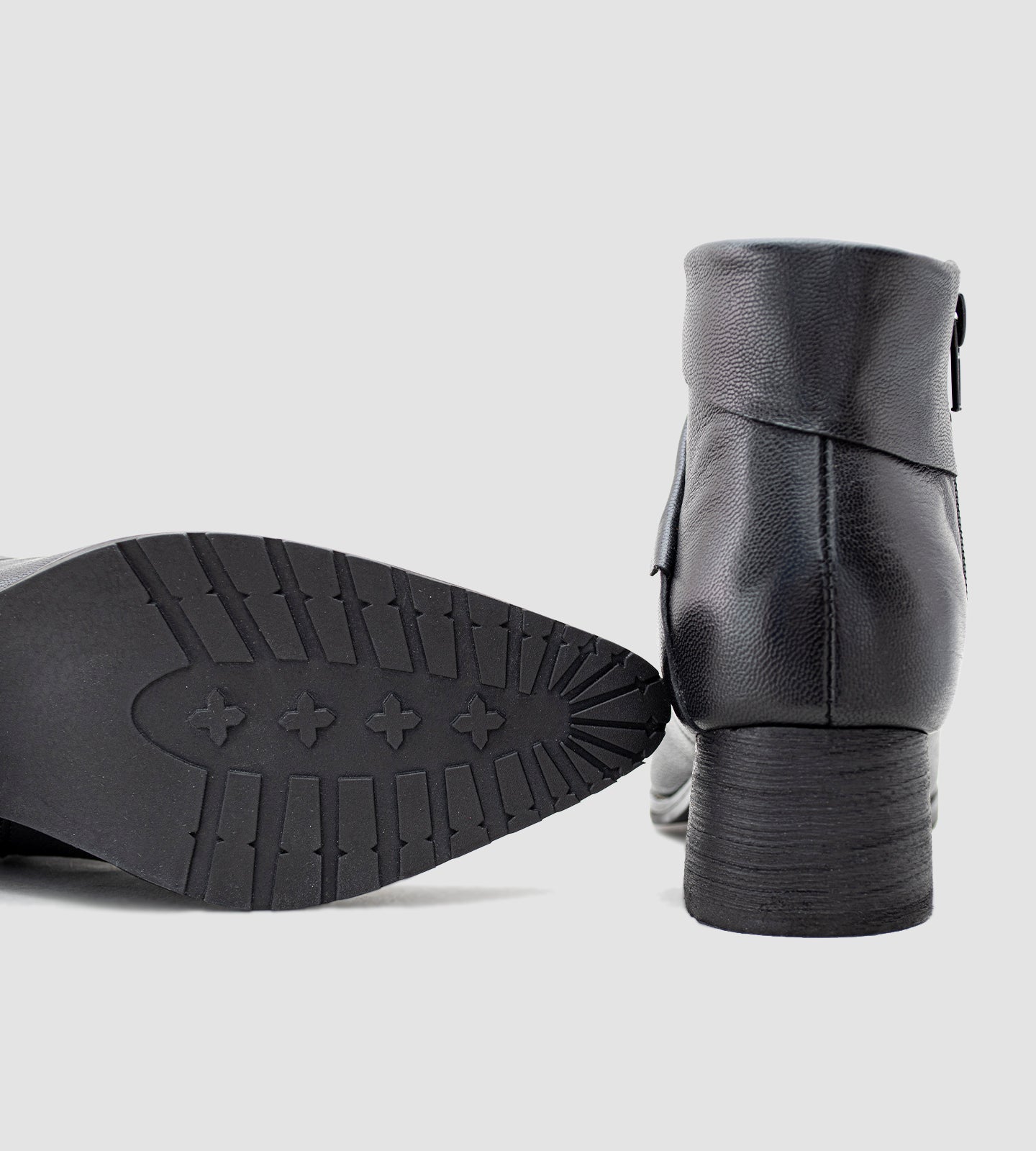 Bota feminina de cano curto confeccionada em couro legítimo preto, com acabamento texturizado e detalhe transpassado no tornozelo que traz um toque moderno e sofisticado ao design. Com salto grosso baixo e solado emborrachado, é uma peça versátil e confortável, ideal para compor looks elegantes no dia a dia ou em produções urbanas.