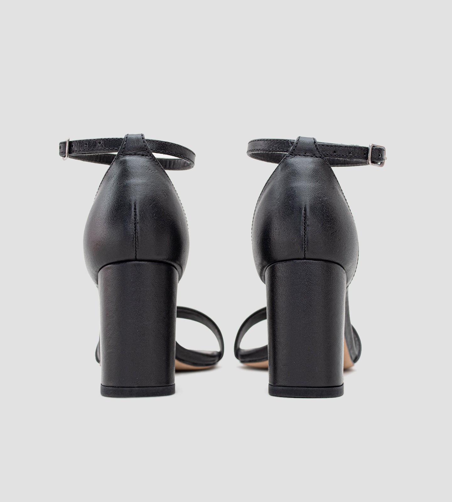 Sandália clássica em couro preto com salto grosso de 7 cm, alça ajustável no tornozelo e tira única sobre os dedos. Modelo elegante e confortável, ideal para ocasiões especiais e eventos em diferentes tipos de terreno.