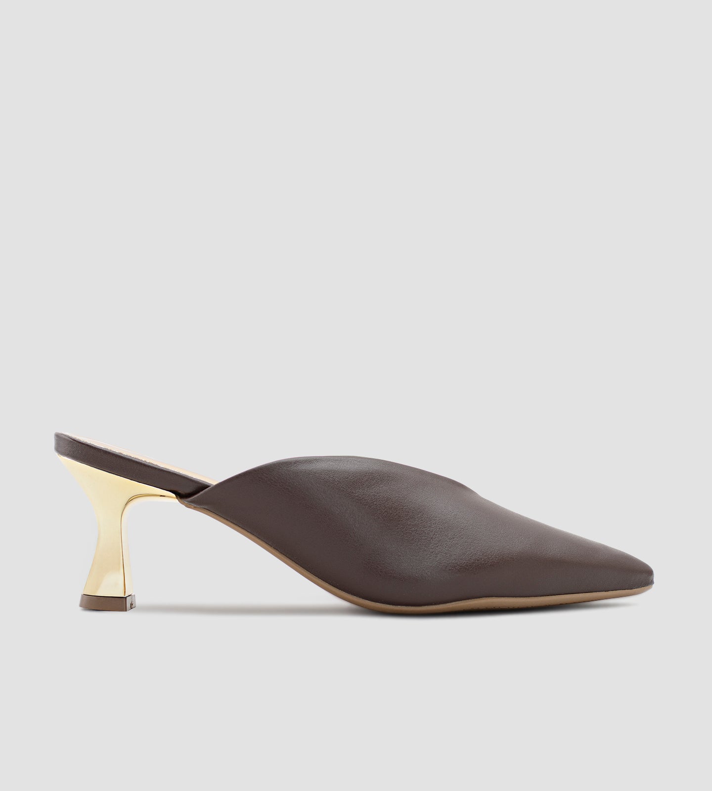 Mule marrom em napa com bico fino e salto dourado escultural de 7cm, combinando design moderno, elegância e conforto.