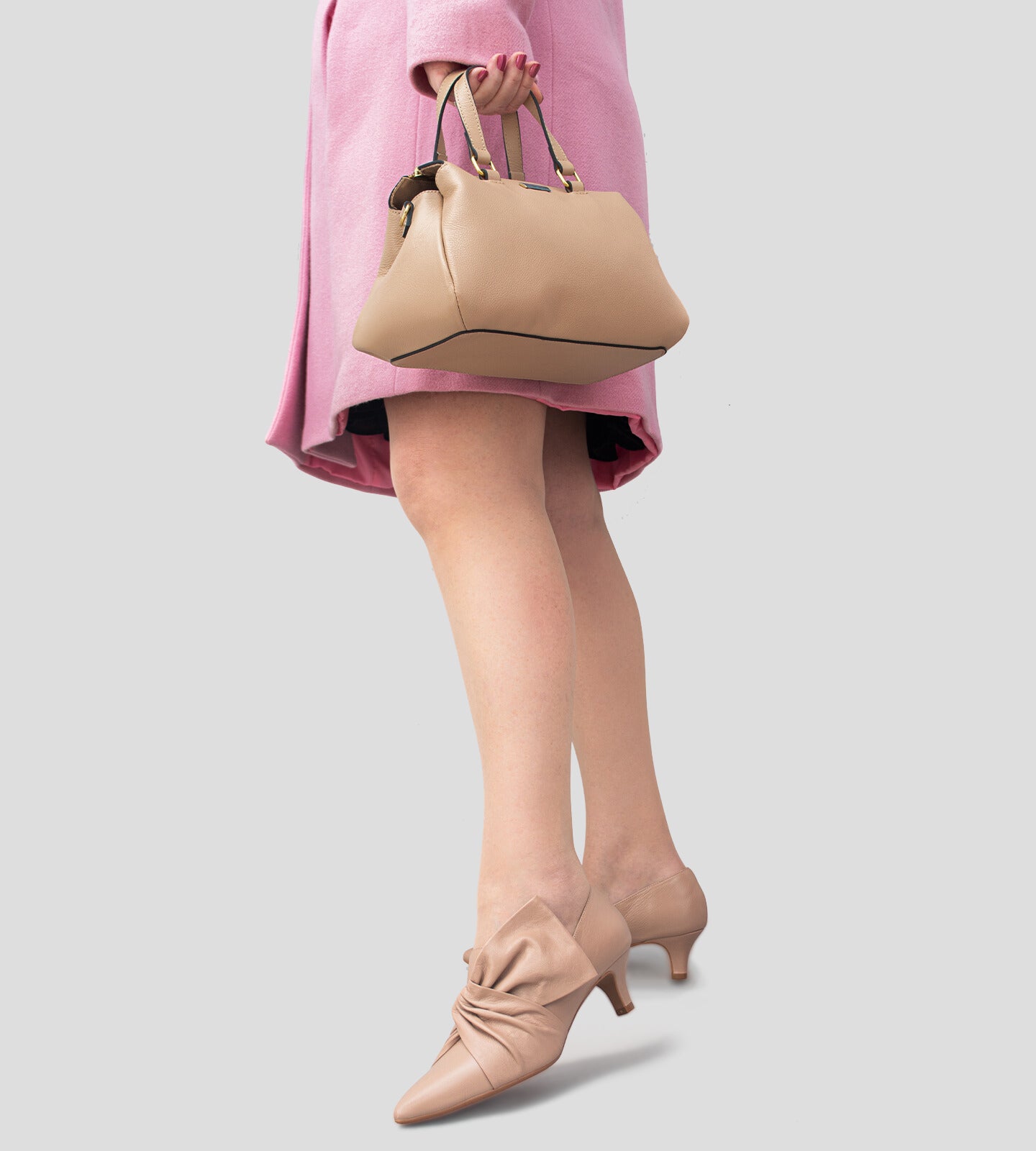 Scarpin feminino de couro nude com salto baixo de 5 cm e detalhe em laço torcido no cabedal, exibindo um design elegante e sofisticado.