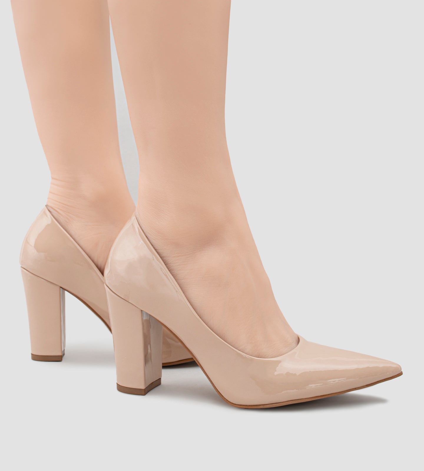 Scarpin feminino de verniz nude com salto grosso de 10 cm, design clássico de bico fino, ideal para eventos formais ou ocasiões especiais, destacando elegância e sofisticação.