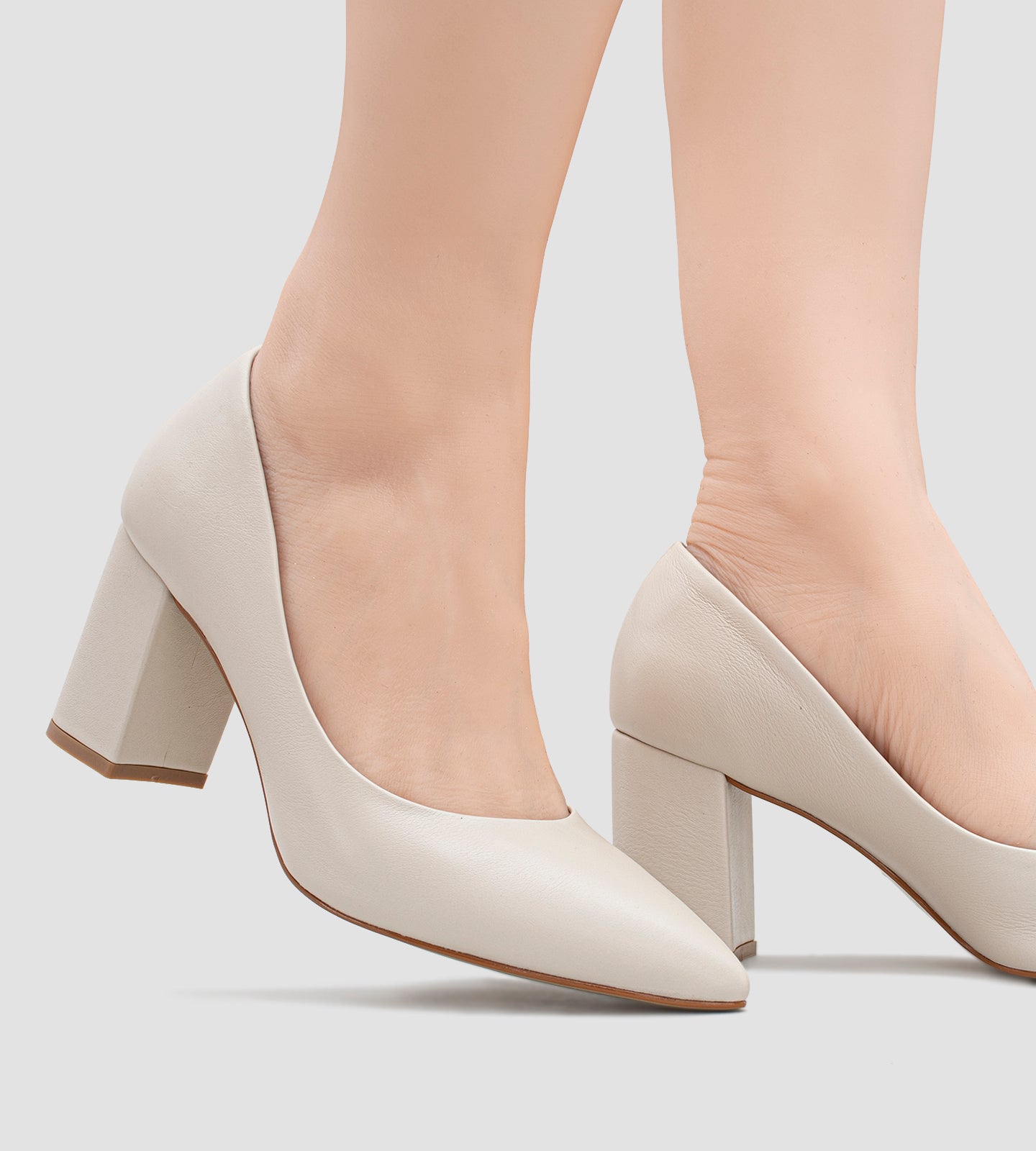 Scarpin feminino na cor marfim com acabamento fosco, salto grosso de 7 cm e bico fino, exibindo um design clássico e elegante ideal para eventos formais ou uso no dia a dia.