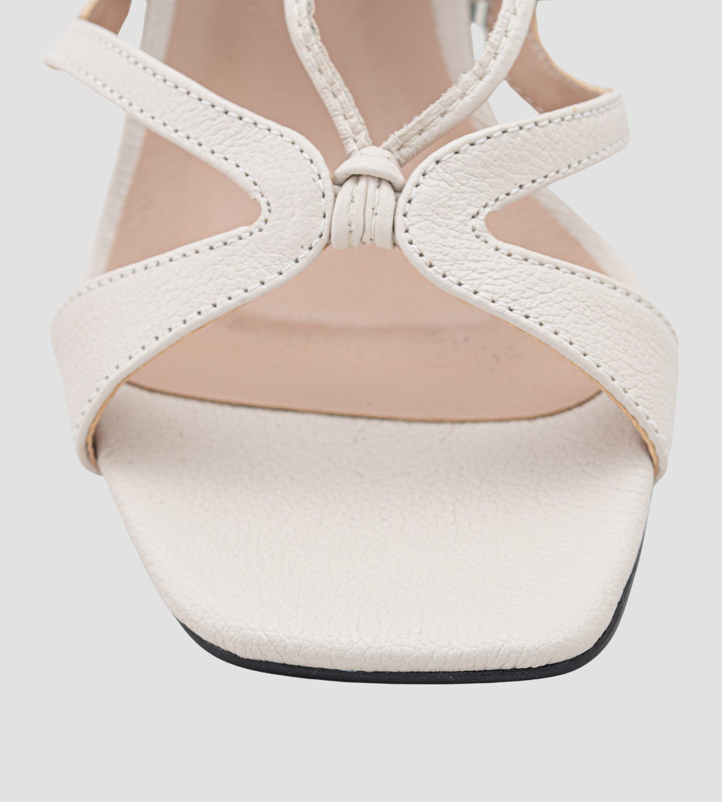 Sandália de couro nude com salto bloco e amarração no tornozelo. O modelo apresenta tiras finas delicadas, design sofisticado e acabamento refinado, ideal para festas e ocasiões especiais. O salto médio proporciona conforto e elegância, combinando perfeitamente com looks modernos e sofisticados.