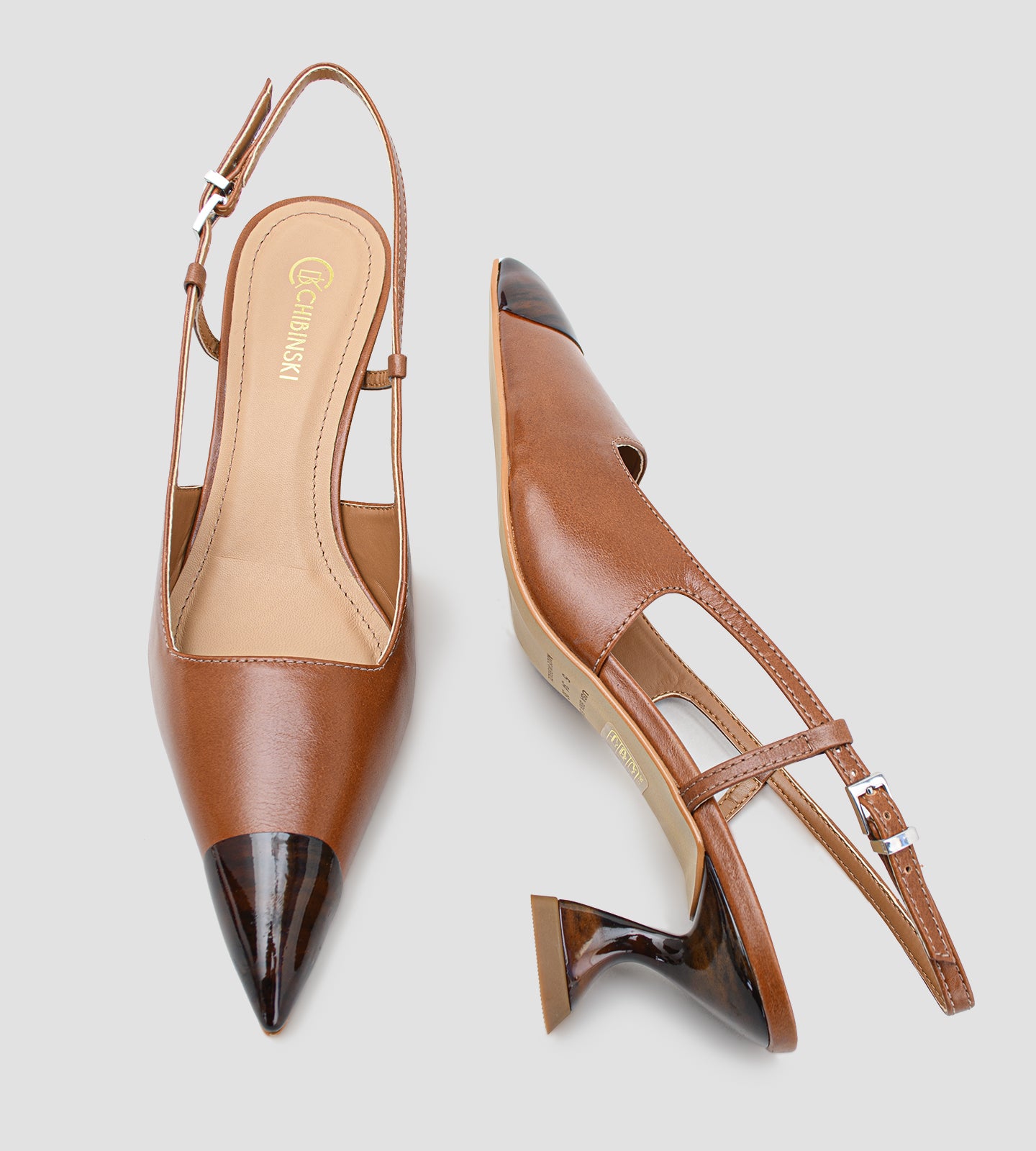 Fotografia de um par de sapatos femininos modelo scarpin slingback na cor caramelo sobre um fundo claro. O calçado possui bico fino com a ponta envernizada em estampa de tartaruga, além de um salto escultural de 6 centímetros com o mesmo padrão de tartaruga. O fechamento é feito por uma tira fina com fivela prateada ajustável no calcanhar.