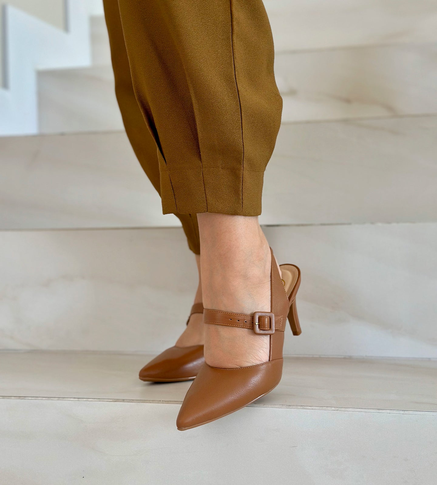 Scarpin Slingback Marrom com Salto Médio e Bico Fino, confeccionado em couro marrom com acabamento sofisticado. O modelo possui bico fino, salto de 8 cm e tira slingback ajustável, garantindo conforto e segurança ao caminhar. Ideal para compor looks elegantes, combina perfeitamente com vestidos, saias e alfaiataria.