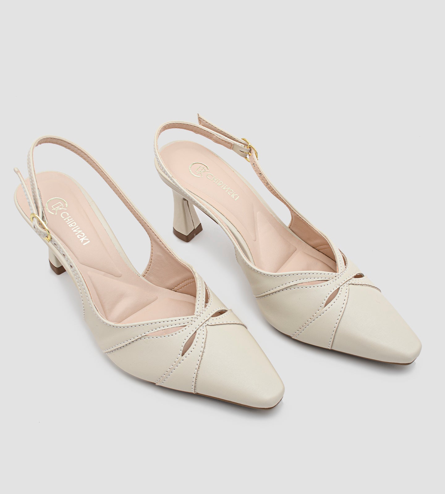 Scarpin slingback bege da marca CHIBINSKI, feito em napa macia com bico fino e salto alto fino de 8 cm. O calçado tem recortes delicados, tira ajustável no calcanhar com fivela dourada e design elegante, ideal para looks sofisticados e versáteis.