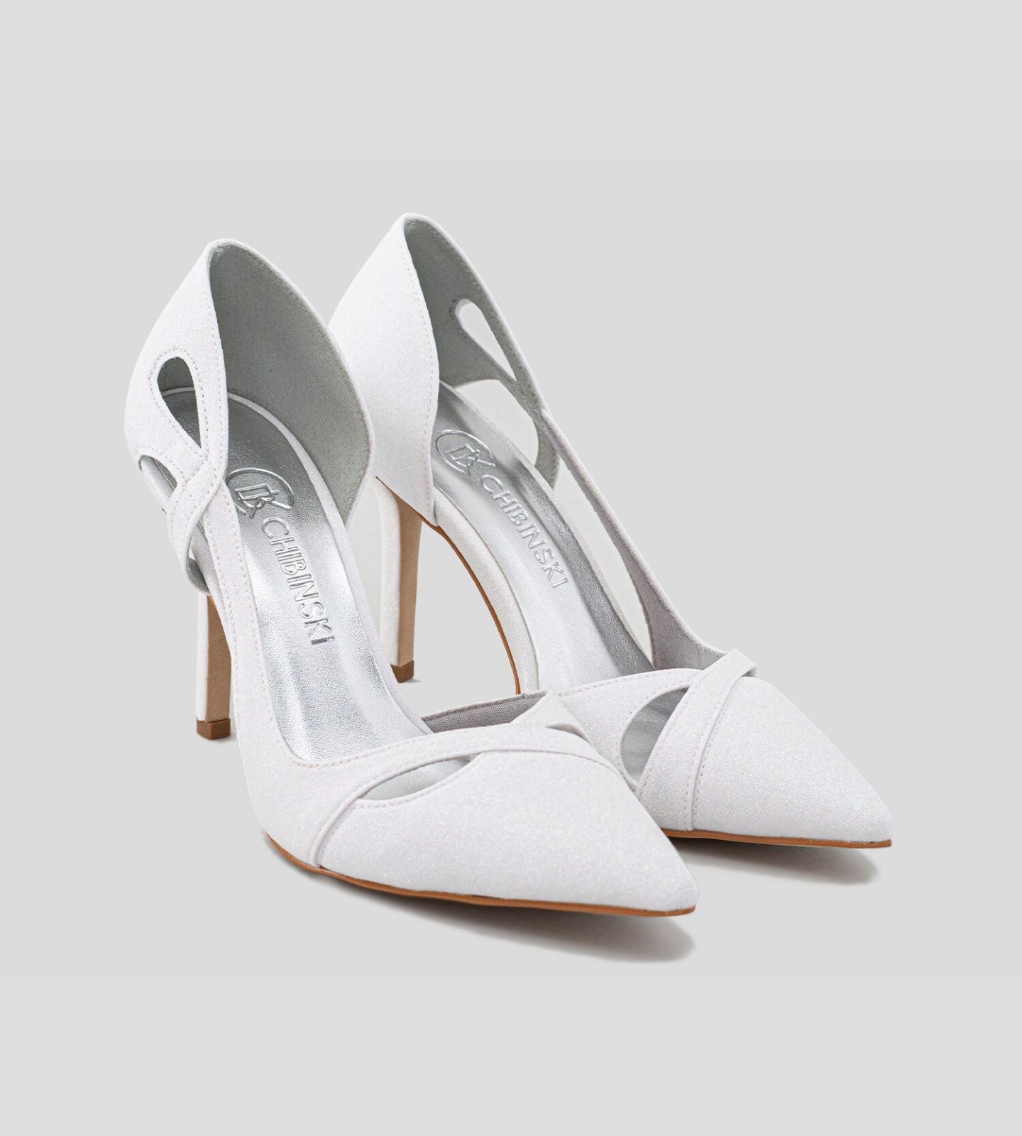 Scarpin sofisticado com recortes laterais e acabamento em glitter branco. O modelo destaca-se pelo seu design elegante, perfeito para ocasiões especiais. Com um salto gracioso e uma silhueta estilosa, este scarpin oferece conforto e um toque de brilho, ideal para complementar vestidos e looks festivos.