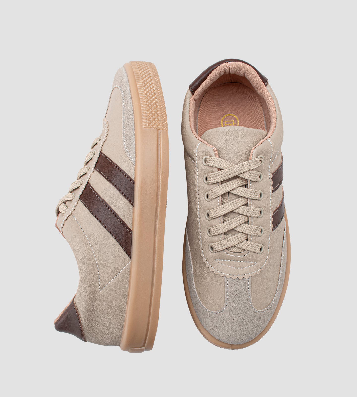 Tênis feminino casual bege com listras marrons, detalhe em camurça no bico, solado caramelo e fechamento em cadarço.