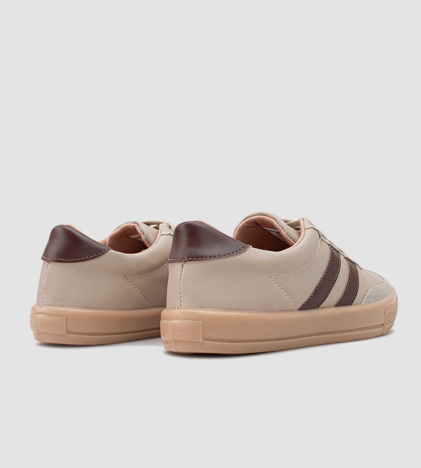 Tênis feminino casual bege com listras marrons, detalhe em camurça no bico, solado caramelo e fechamento em cadarço.