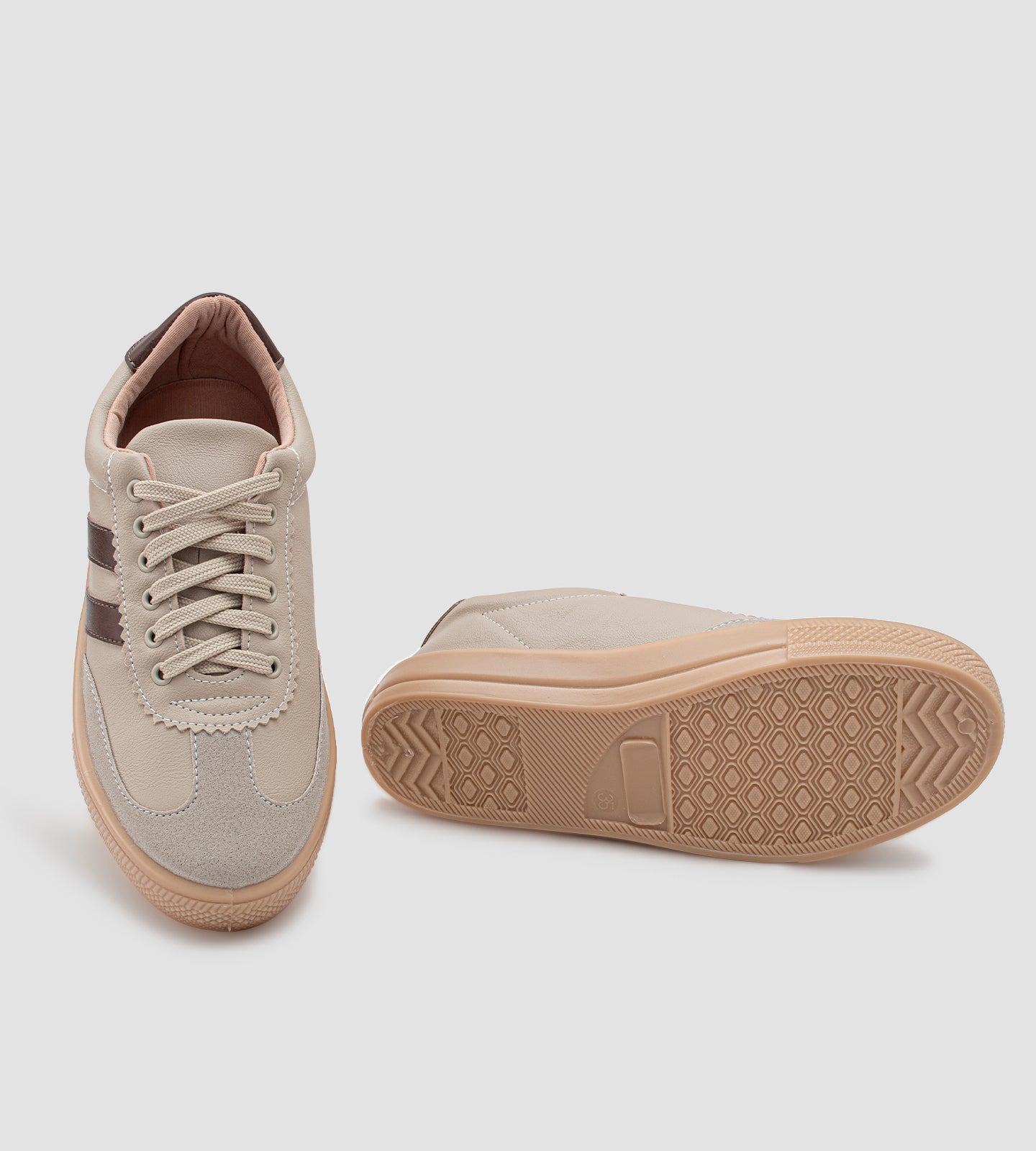 Tênis feminino casual bege com listras marrons, detalhe em camurça no bico, solado caramelo e fechamento em cadarço.