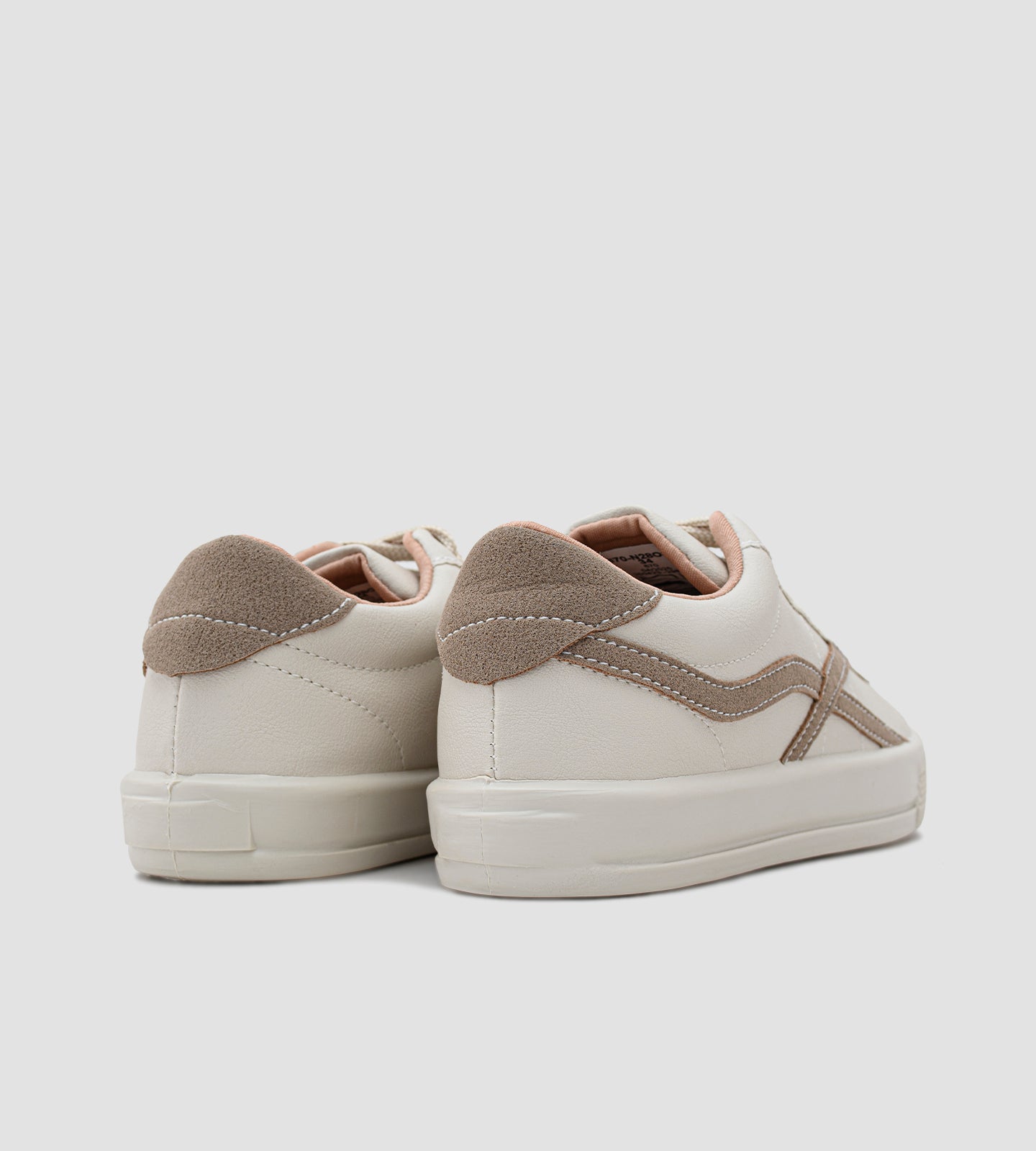 Um tênis casual feminino de cor off-white, com detalhes em bege e um toque sutil de rosa claro, que remete à versatilidade e ao estilo de modelos populares como o Adidas Samba, a silhueta clássica do New Balance 530 e o design consciente dos tênis Veja (anteriormente conhecidos como Vert no Brasil).