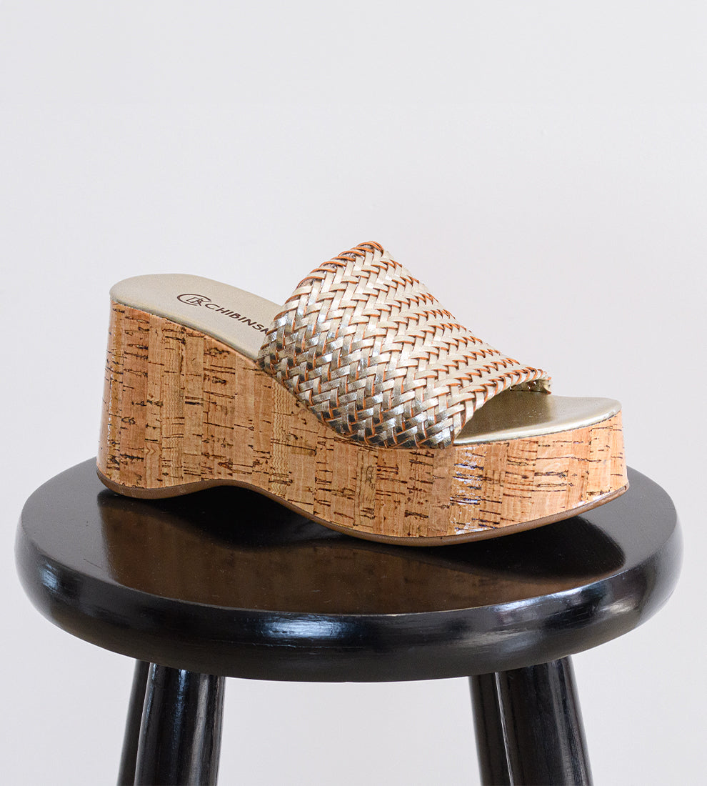 Tamanco feminino dourado com salto plataforma em cortiça e tiras largas trançadas.