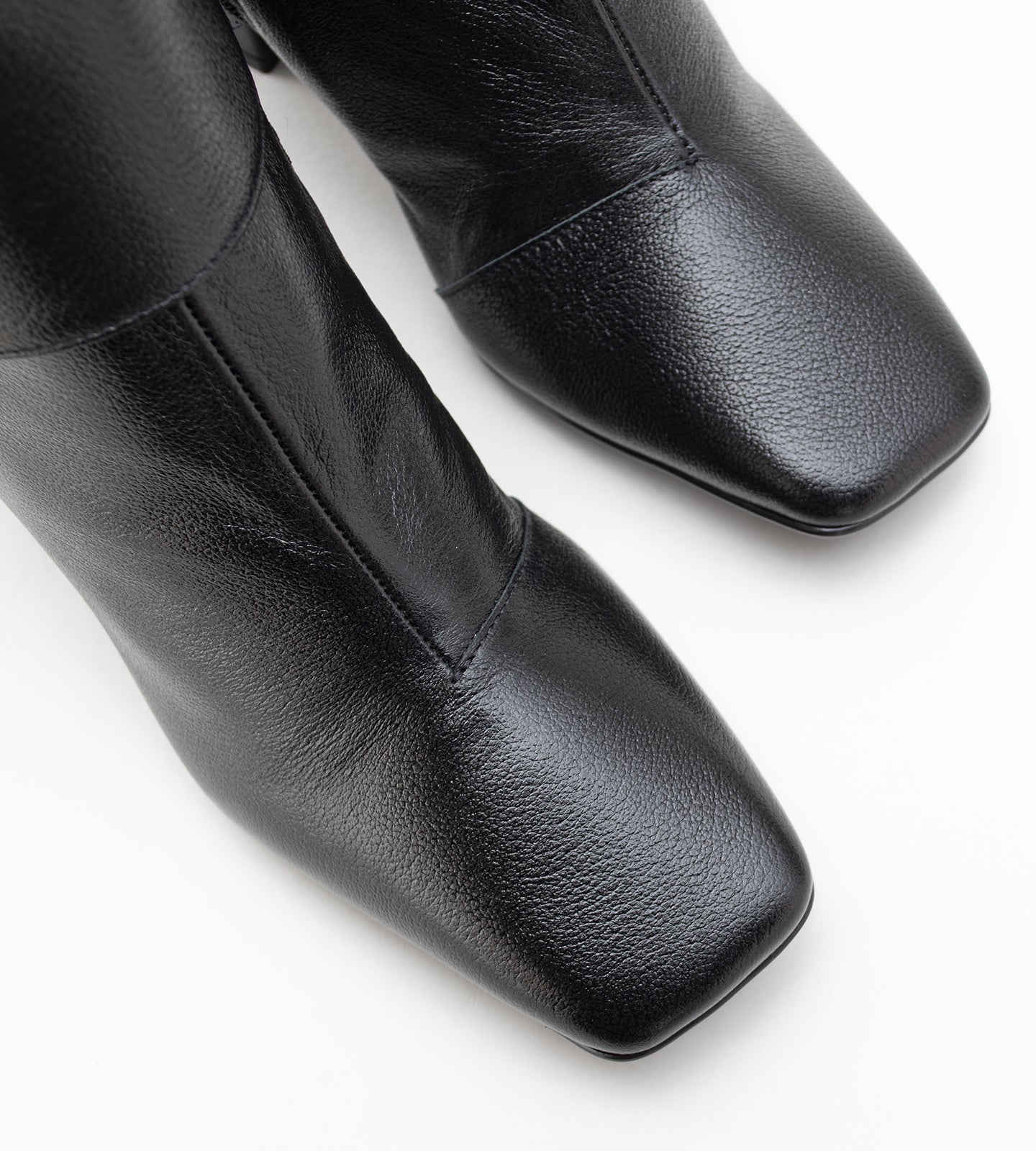 Bota feminina cano médio em couro preto com bico quadrado, salto bloco médio e fechamento em zíper lateral, design moderno e elegante.