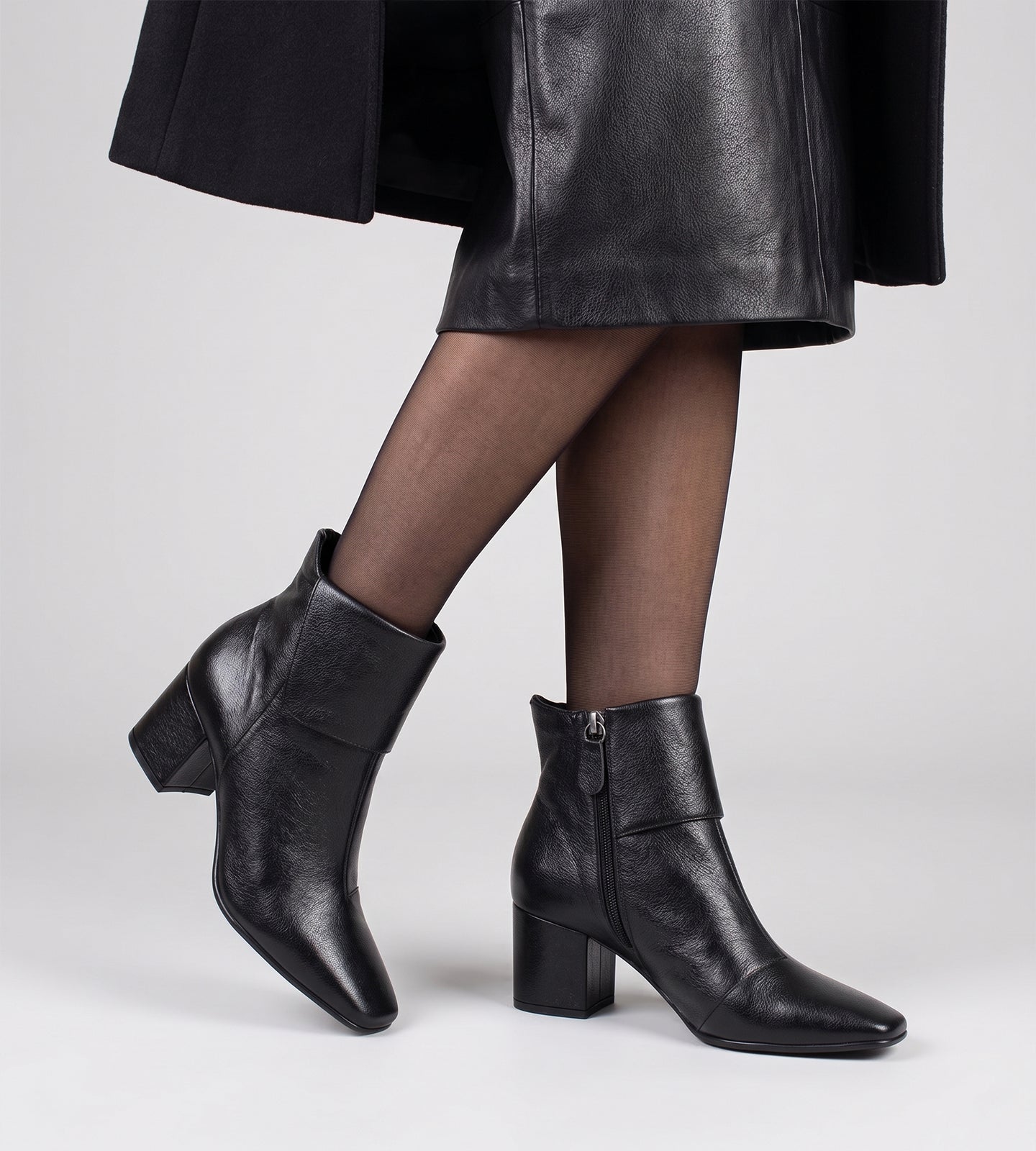 Bota feminina cano médio em couro preto com bico quadrado, salto bloco médio e fechamento em zíper lateral, design moderno e elegante.