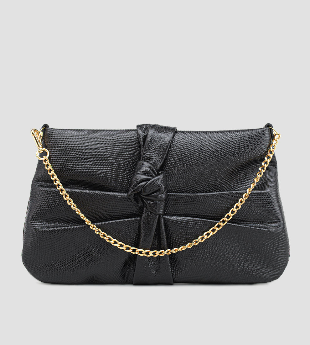 Bolsa feminina em couro preto com nó frontal, corrente dourada e alça ajustável removível.