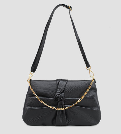 Bolsa feminina em couro preto com nó frontal, corrente dourada e alça ajustável removível.