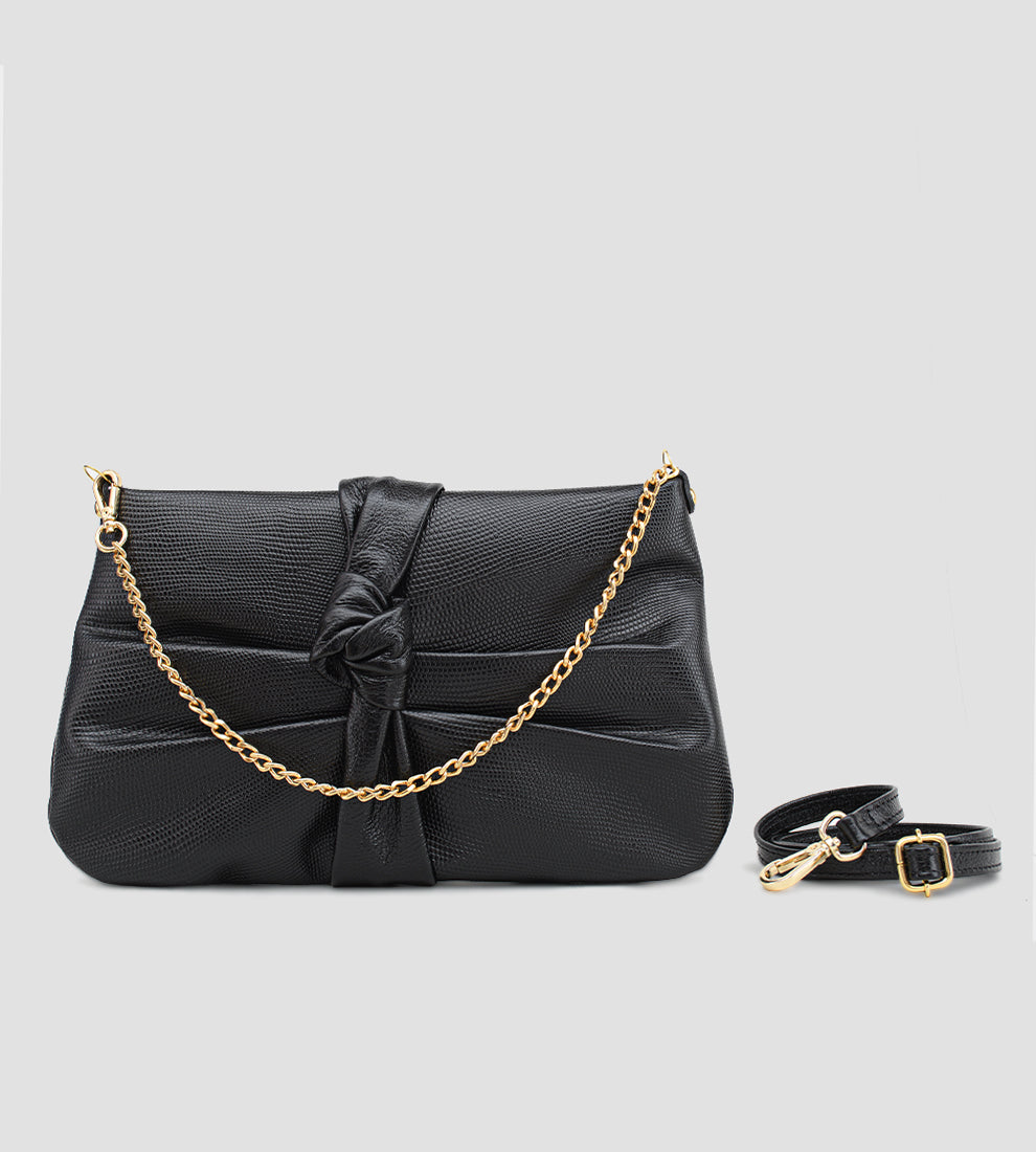 Bolsa feminina em couro preto com nó frontal, corrente dourada e alça ajustável removível.