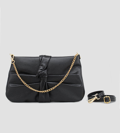 Bolsa feminina em couro preto com nó frontal, corrente dourada e alça ajustável removível.