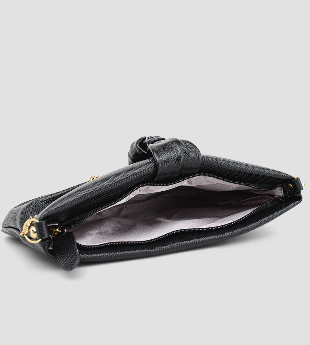 Bolsa feminina em couro preto com nó frontal, corrente dourada e alça ajustável removível.