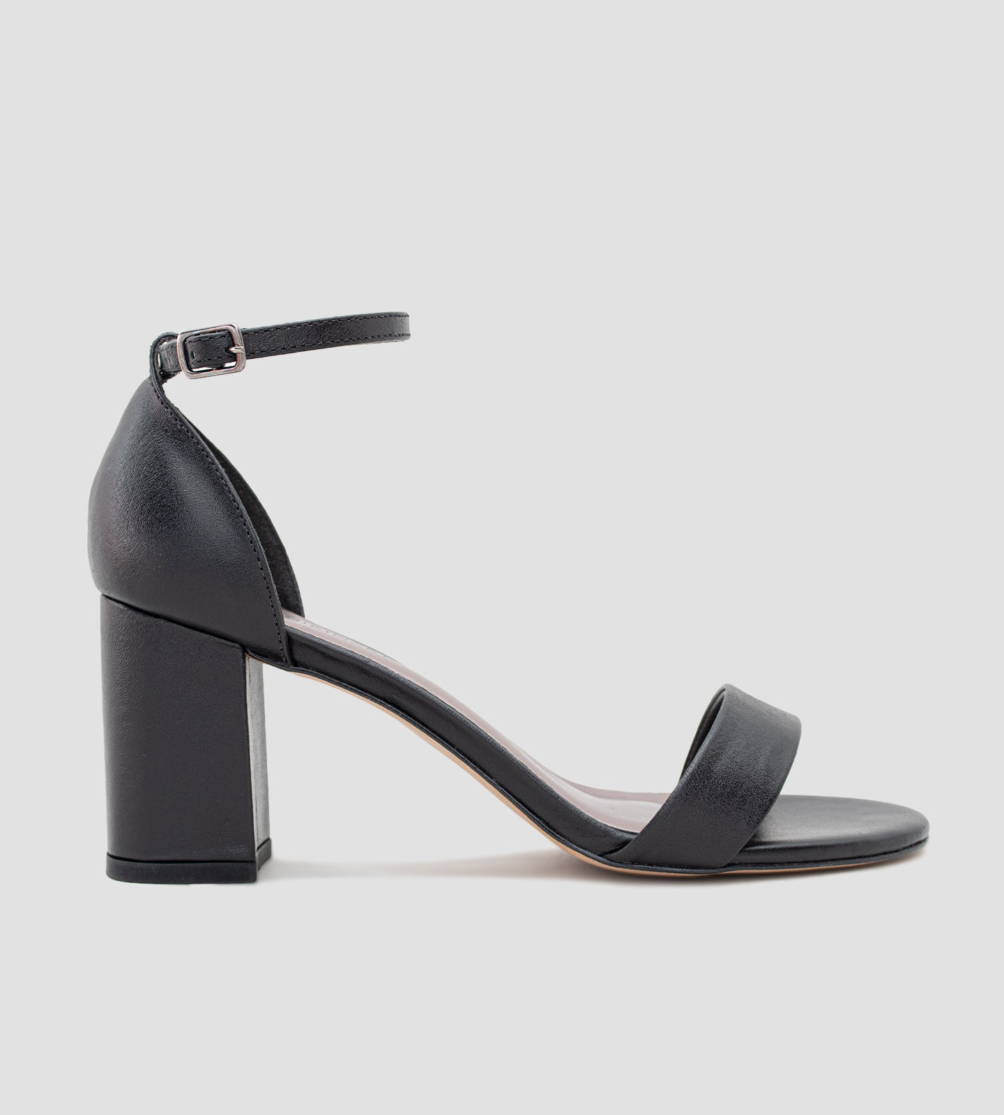 Sandália clássica em couro preto com salto grosso de 7 cm, alça ajustável no tornozelo e tira única sobre os dedos. Modelo elegante e confortável, ideal para ocasiões especiais e eventos em diferentes tipos de terreno.