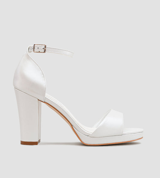 Sandália feminina em couro branco perolado, com meia-pata frontal e salto bloco de 10 cm, vista nos pés, com tira no tornozelo e acabamento elegante.