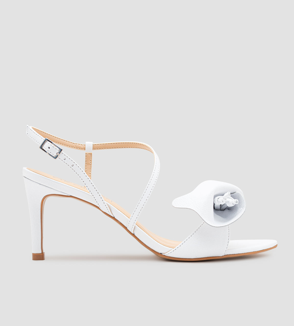 Sandália de noiva em couro branco com salto fino de 9 cm, tiras delicadas, detalhe floral artesanal na parte frontal e fechamento ajustável no tornozelo.