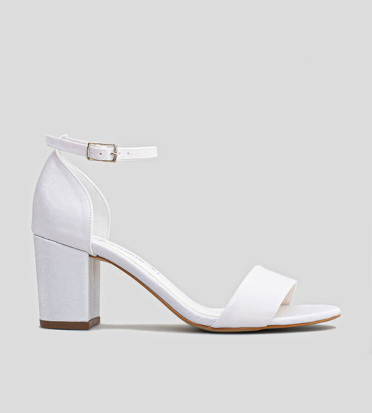 Sandália de noiva branca com salto bloco de 7 cm em velvet com brilho sutil, tira frontal e fechamento no tornozelo, vista lateral em fundo neutro, elegante e confortável para casamento.