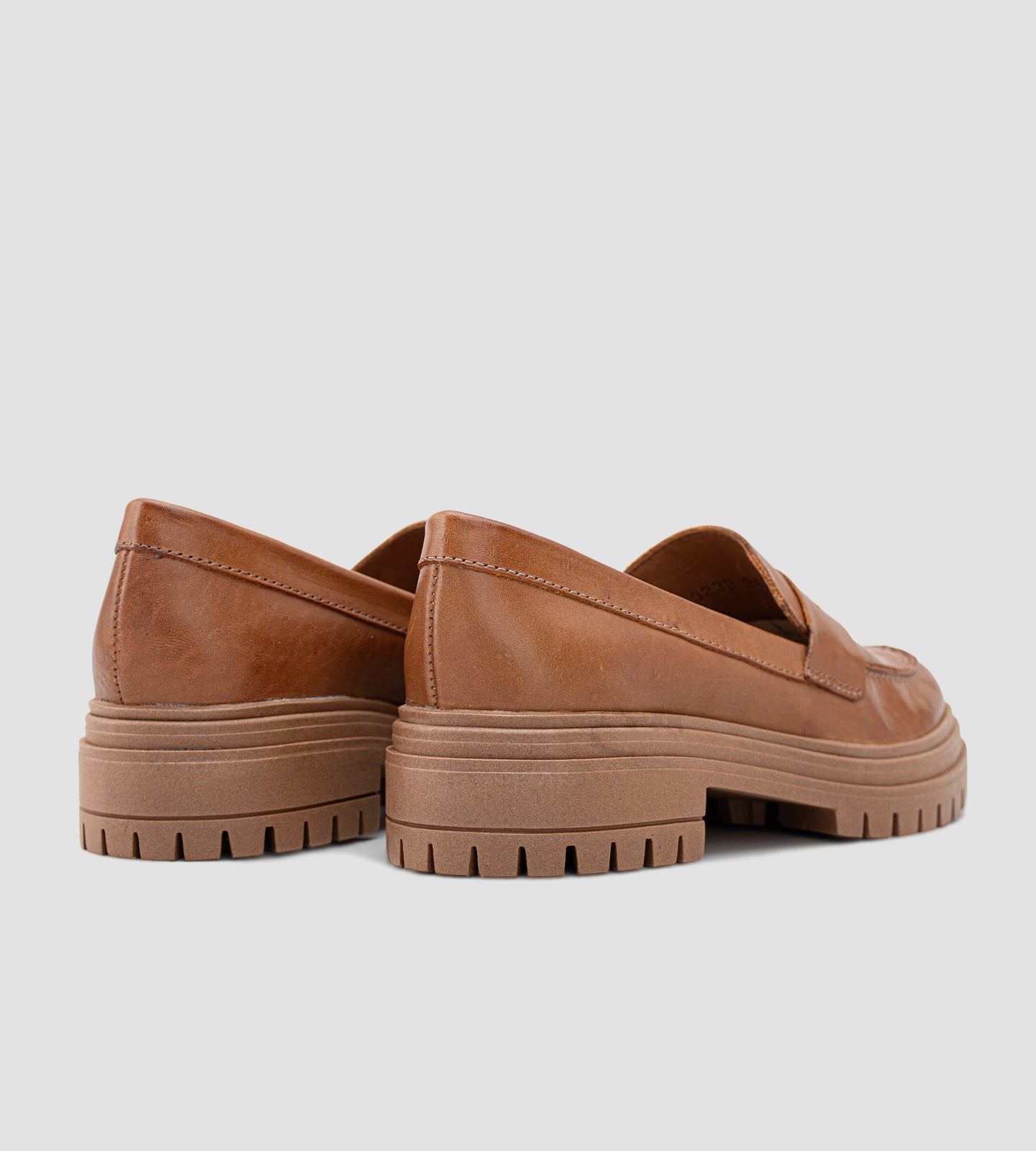 Mocassim feminino de couro marrom com salto tratorado, detalhe em costura aparente e sola robusta antiderrapante, ideal para looks modernos e elegantes.