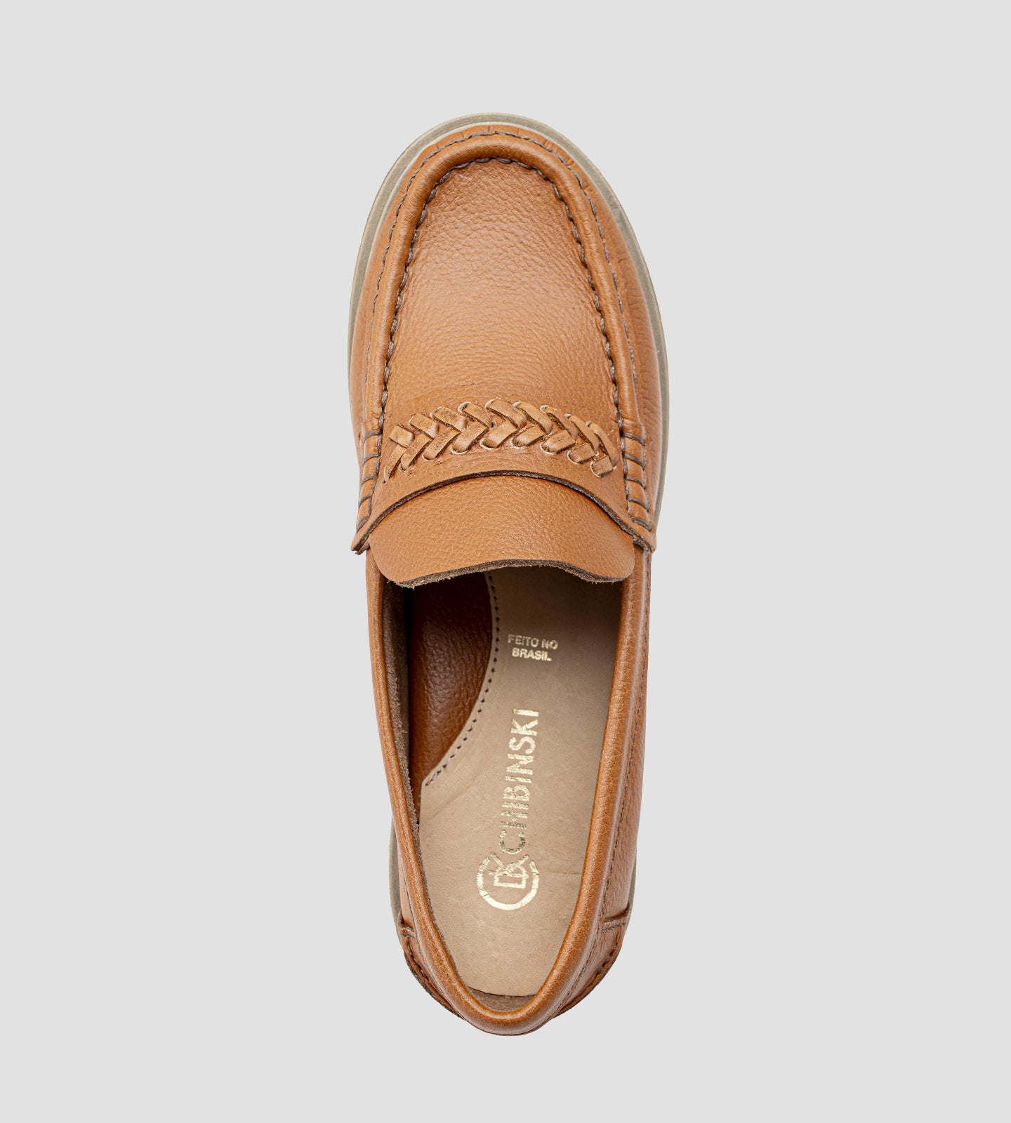 Mocassim feminino em couro marrom com solado tratorado e detalhe trançado em couro.