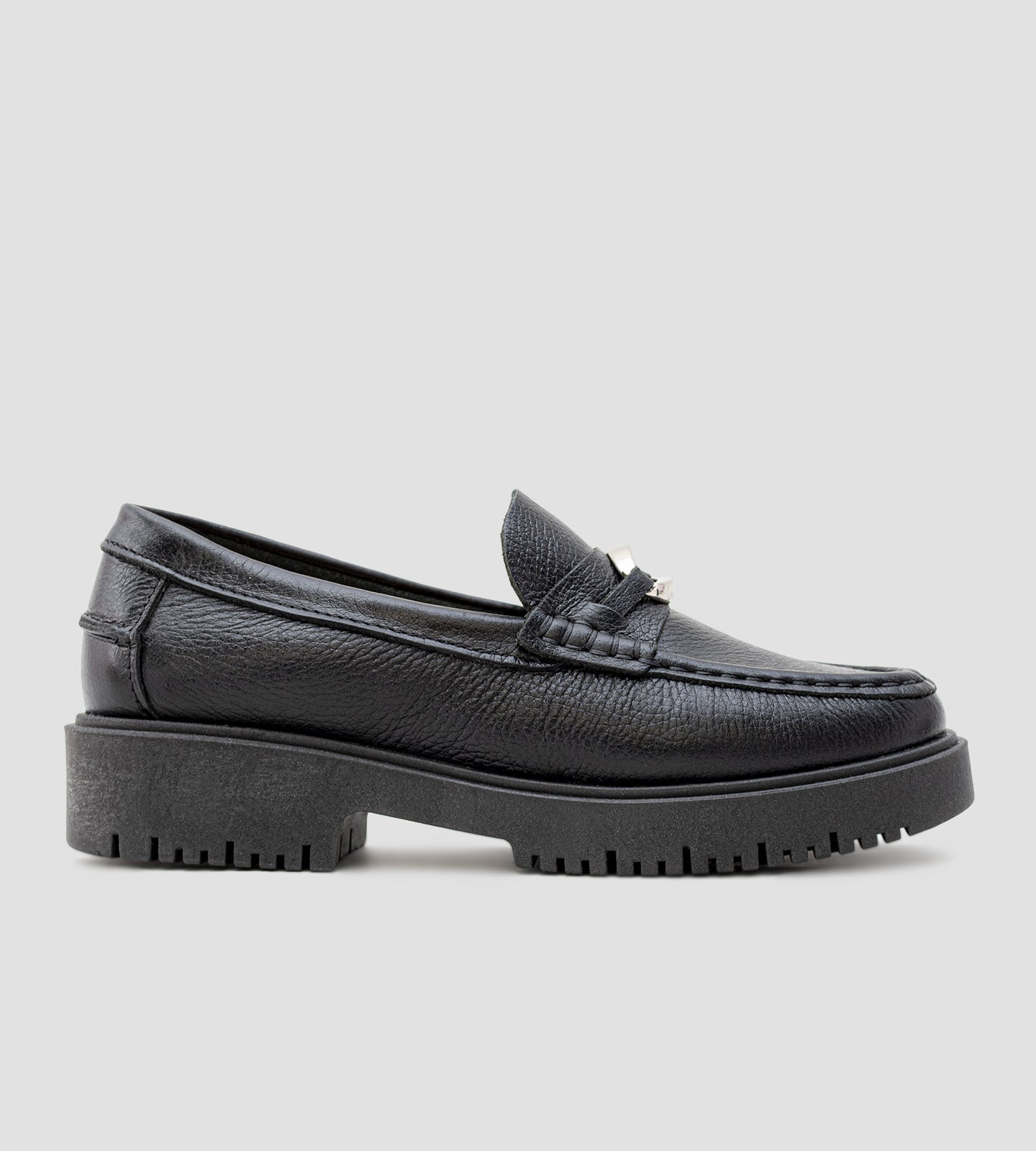 Mocassim feminino em couro preto com solado tratorado e detalhe metálico.