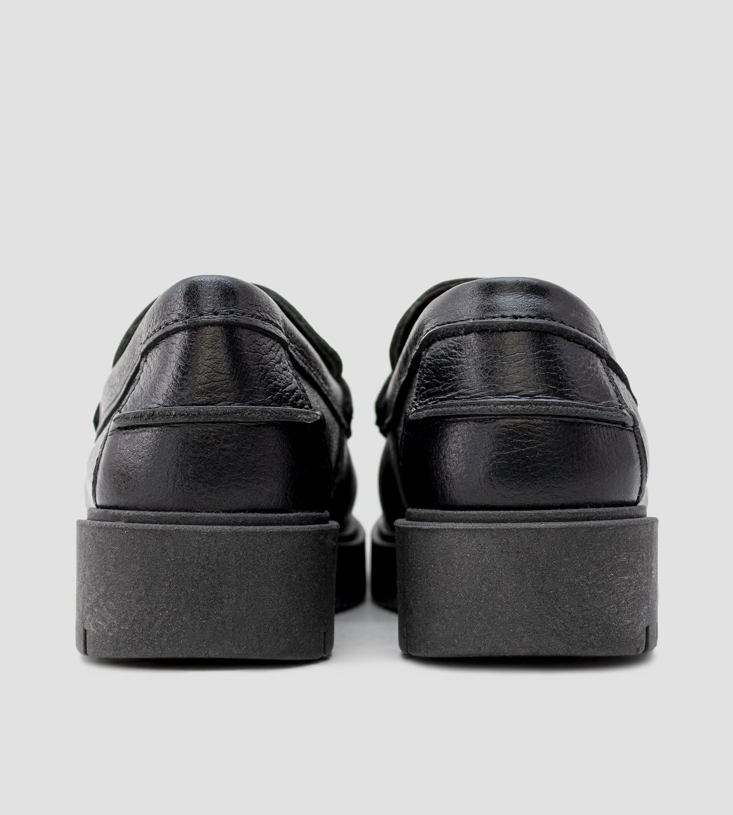 Mocassim feminino em couro preto com solado tratorado e detalhe metálico.