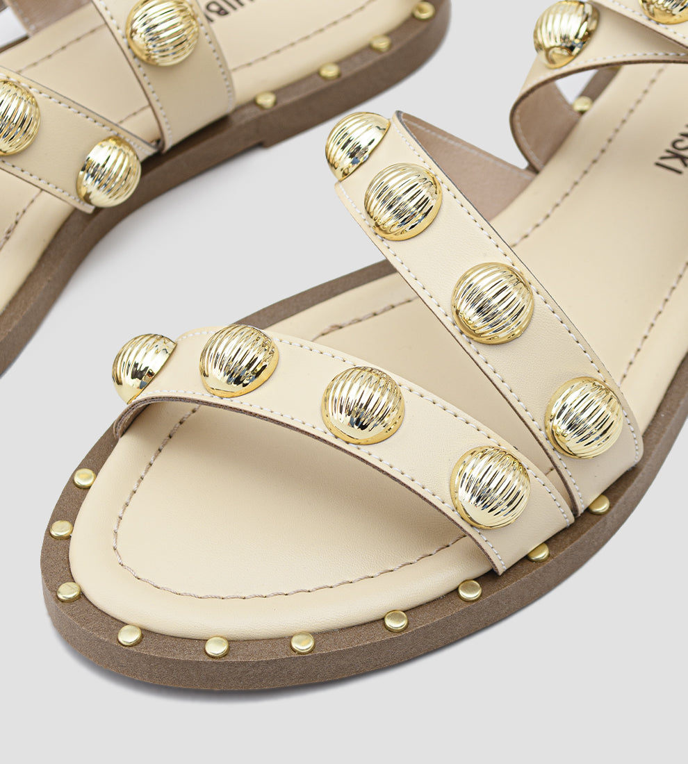 sandália rasteira feminina bege com tiras cruzadas e esferas douradas