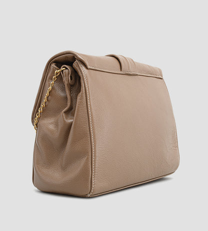 Bolsa feminina em couro marrom com detalhe de nó, corrente dourada e alça ajustável, usada no ombro.