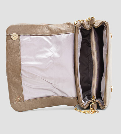 Bolsa feminina em couro marrom com detalhe de nó, corrente dourada e alça ajustável, usada no ombro.