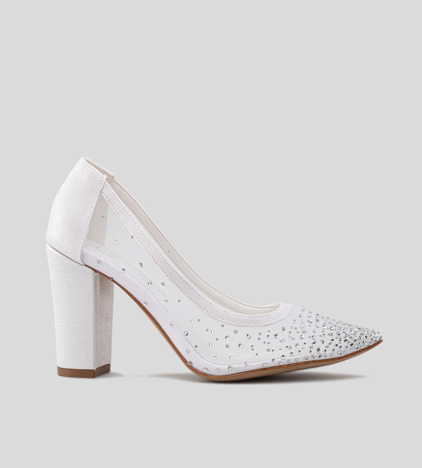 Scarpin de noiva com salto bloco de 10 cm, confeccionado em tela transparente com aplicações de pedrarias e bico fino, combinando elegância, brilho e conforto para o grande dia.
