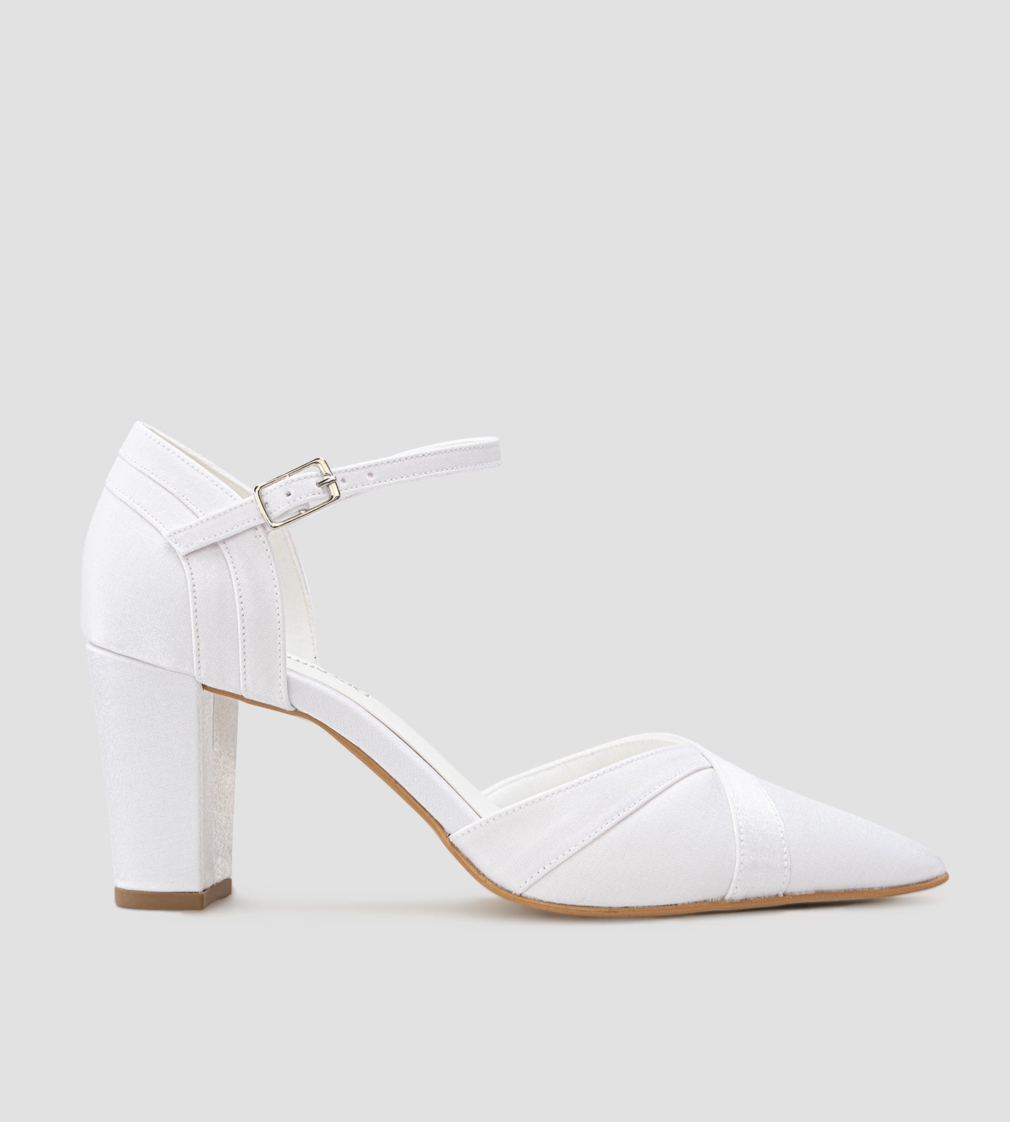 Sapato de noiva scarpin branco em tecido velvet, com bico fino, salto bloco médio de 7 cm e tira no tornozelo com fivela, exibido nos pés com calça clara.