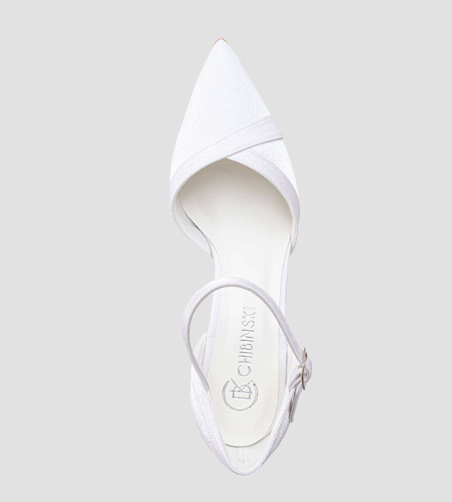 Sapato de noiva scarpin branco em tecido velvet, com bico fino, salto bloco médio de 7 cm e tira no tornozelo com fivela, exibido nos pés com calça clara.
