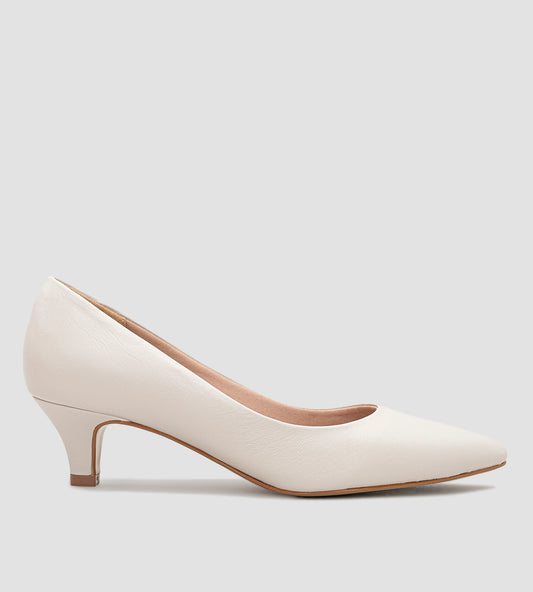 Scarpin feminino na cor marfim com salto baixo de 5 cm e bico fino. O design clássico apresenta acabamento fosco e detalhes minimalistas, ideal para ocasiões formais ou uso diário.