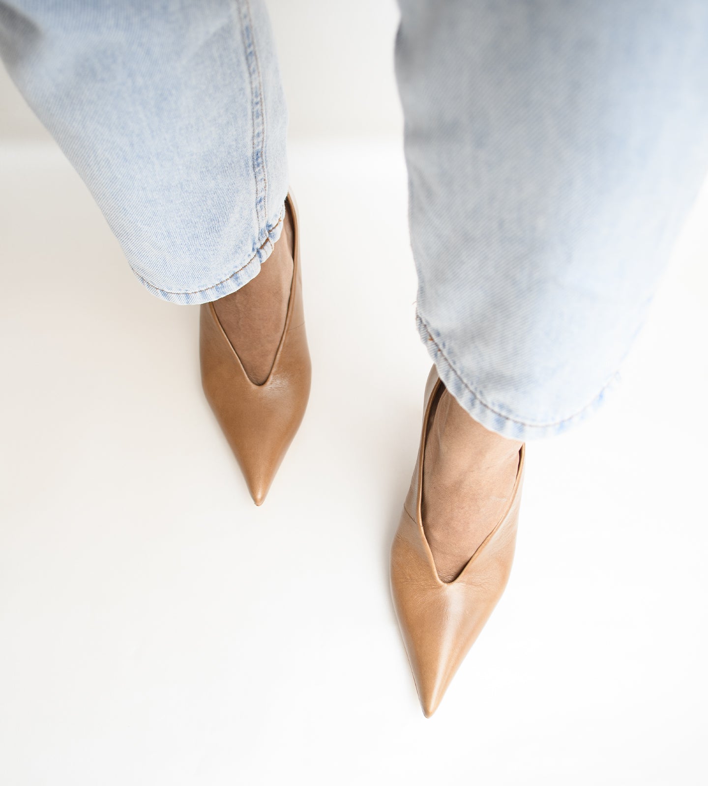 Scarpin feminino de couro marrom com bico fino e salto médio fino de aproximadamente 8 cm, modelo clássico e elegante ideal para trabalho, eventos e looks sofisticados.