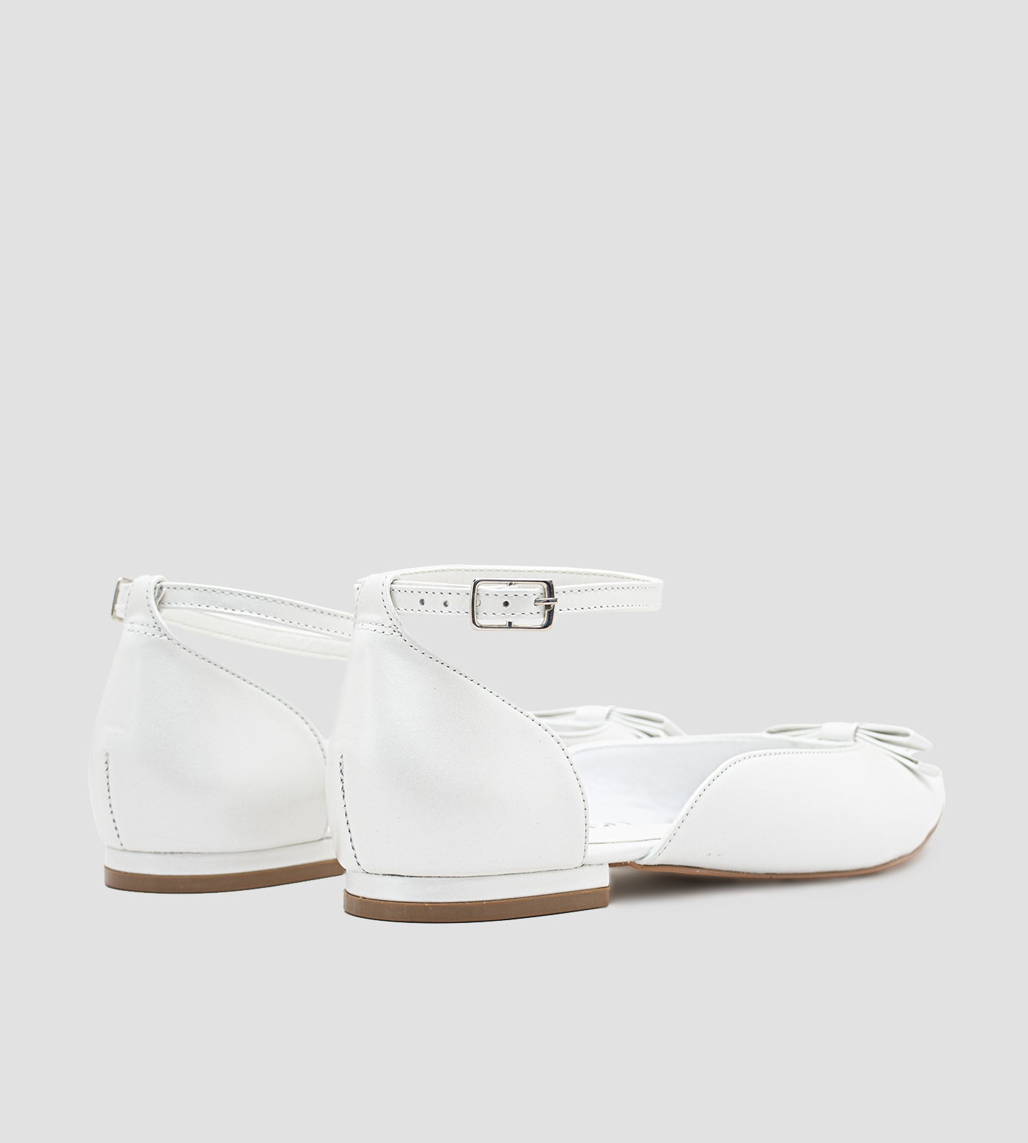 Sapatilha de noiva em couro perolado branco com laço delicado na parte frontal, design elegante e confortável.