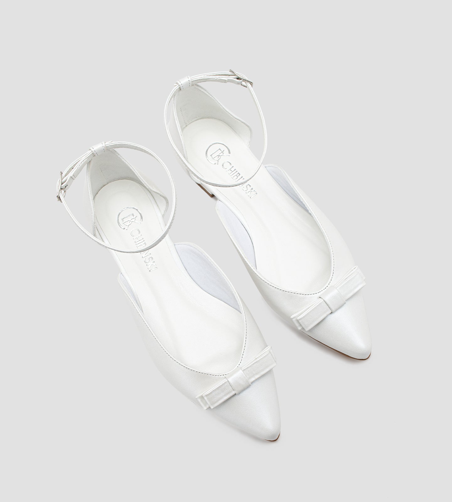 Sapatilha de noiva em couro perolado branco com laço delicado na parte frontal, design elegante e confortável.