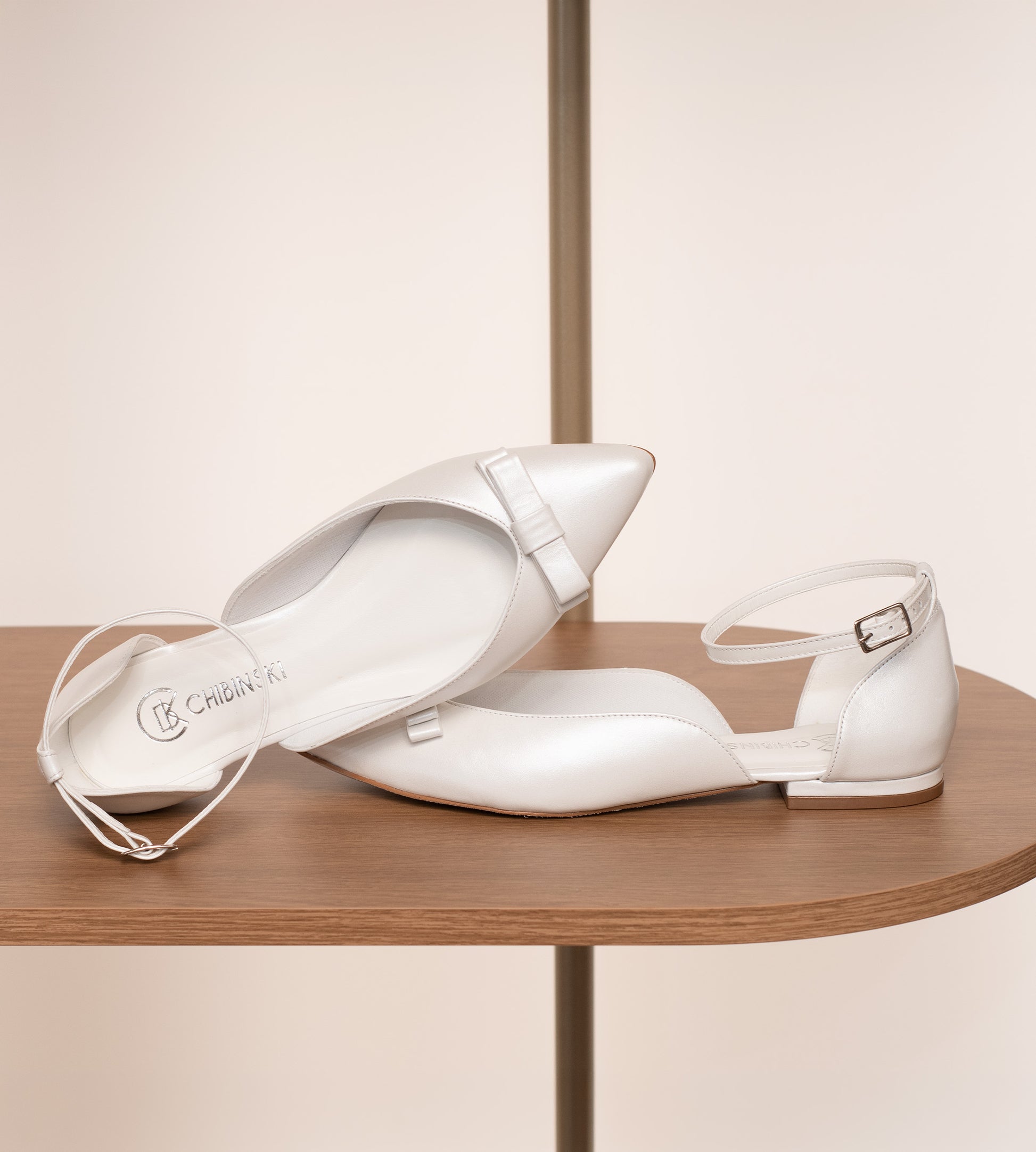 Sapatilha de noiva em couro perolado branco com laço delicado na parte frontal, design elegante e confortável.