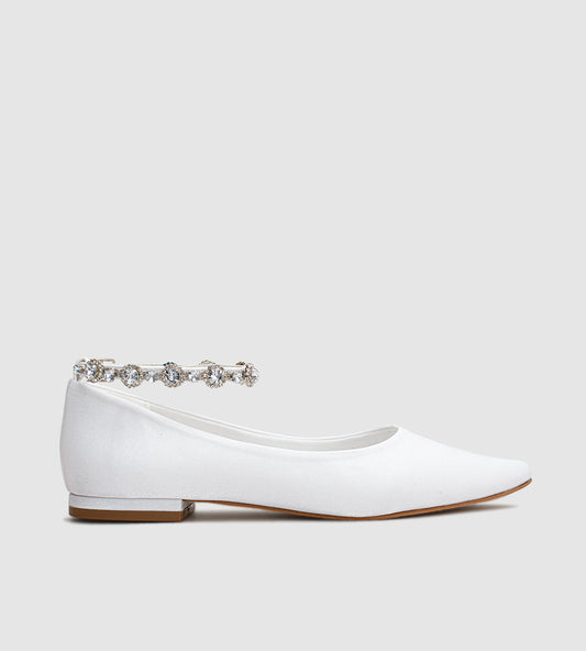 Sapatilha de noiva em material acetinado com acabamento perolado, design minimalista e tornozeleira delicada de strass, ideal para casamentos ao ar livre como no campo ou na praia.