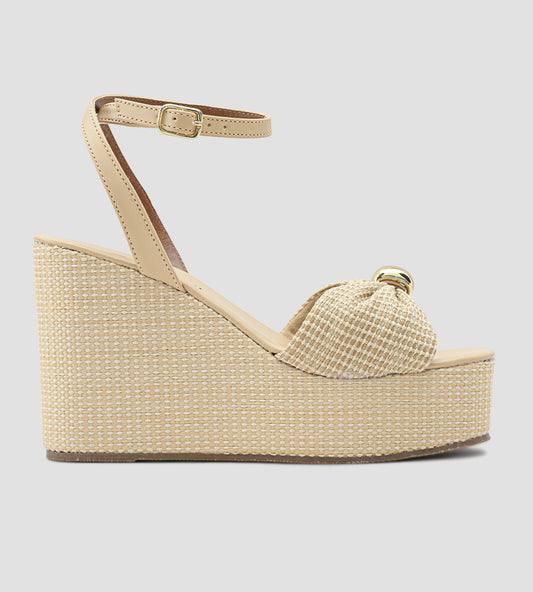 Sandália anabela nude feminina com salto plataforma revestido em palha, tira frontal com nó e fecho de fivela no tornozelo, estilo elegante e confortável para o verão.