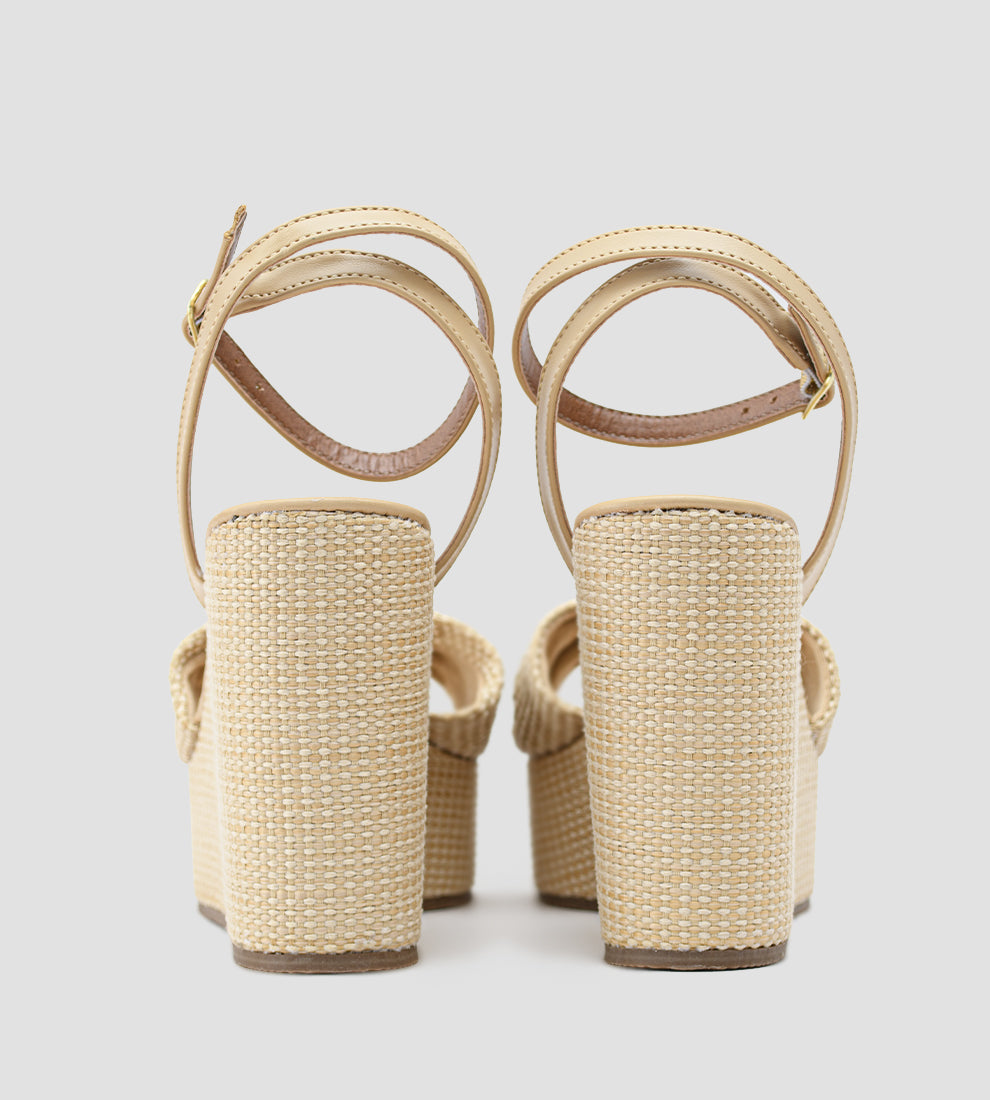 Sandália anabela nude feminina com salto plataforma revestido em palha, tira frontal com nó e fecho de fivela no tornozelo, estilo elegante e confortável para o verão.