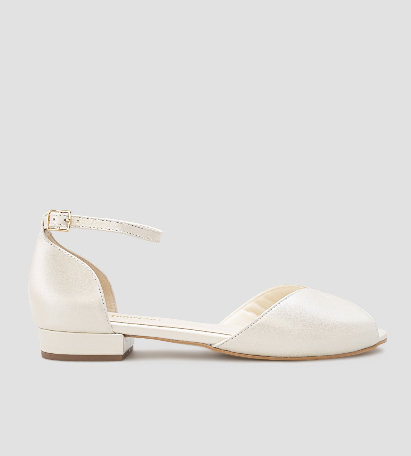 Sandália de noiva estilo sapatilha em couro perolado off white, com bico aberto, tira no tornozelo com fivela e solado baixo, sem salto.