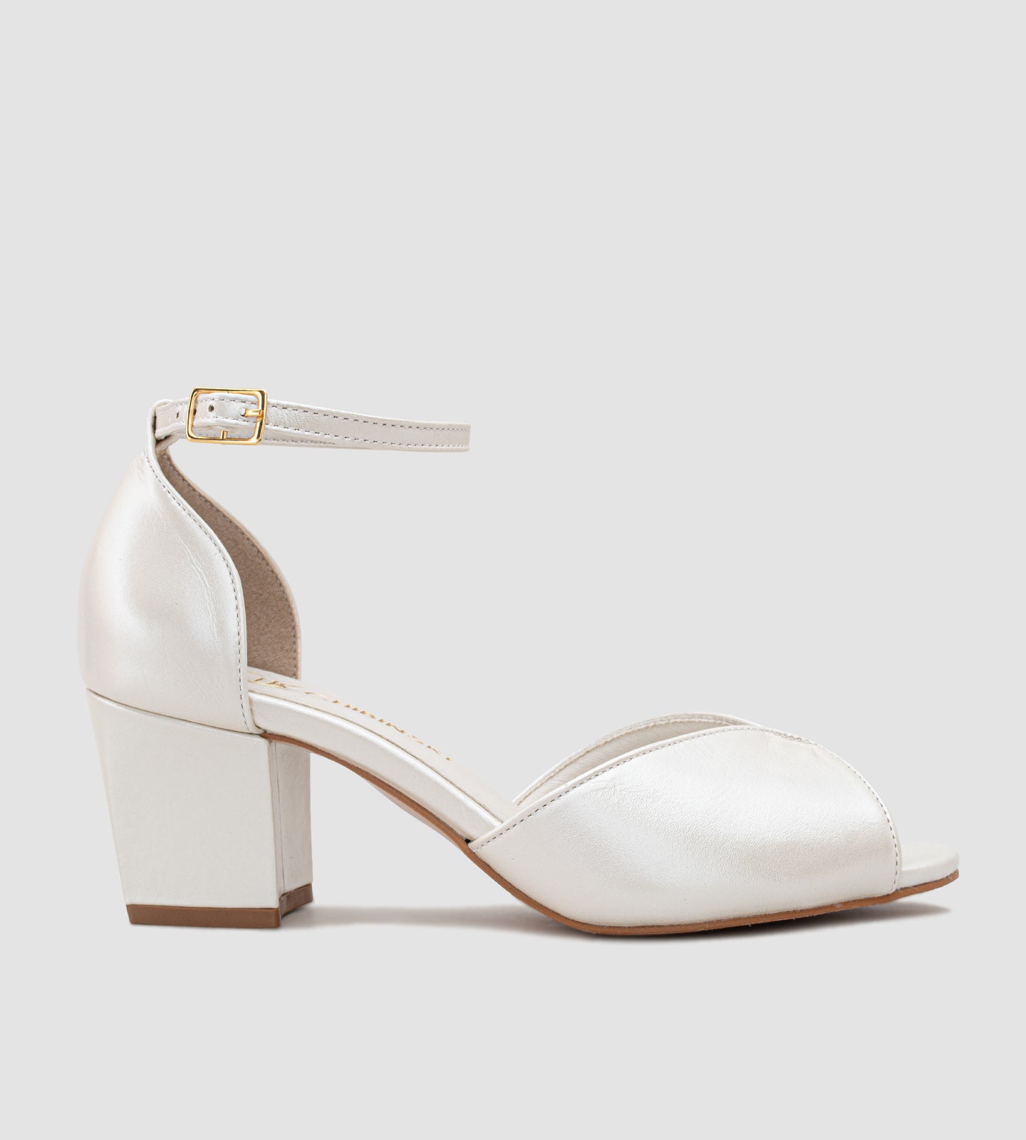 Sandália para noivas em couro perolado off-white, com salto grosso de 5 cm. Modelo elegante, com alça ajustável no tornozelo e design clássico, ideal para proporcionar conforto e estilo em ocasiões especiais.