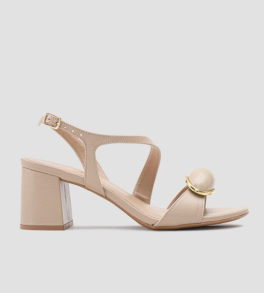 Sandália feminina bege com salto bloco médio e detalhe de pedra com acabamento dourado, elegante e confortável para eventos ou looks casuais.