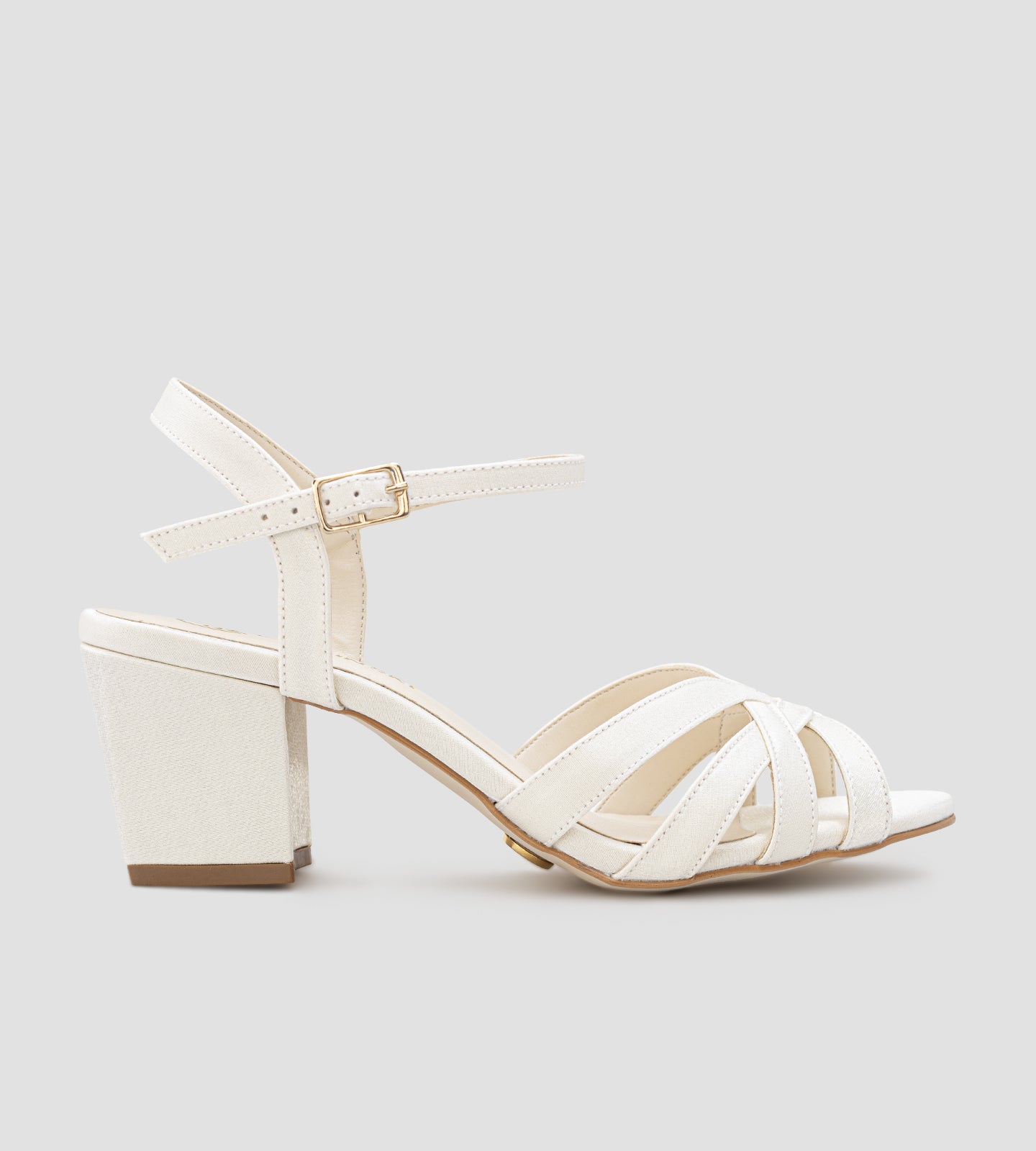 Sandália de noiva em tecido velvet off white, com tiras finas entrelaçadas, salto médio de 7 cm e fechamento no tornozelo com fivela.